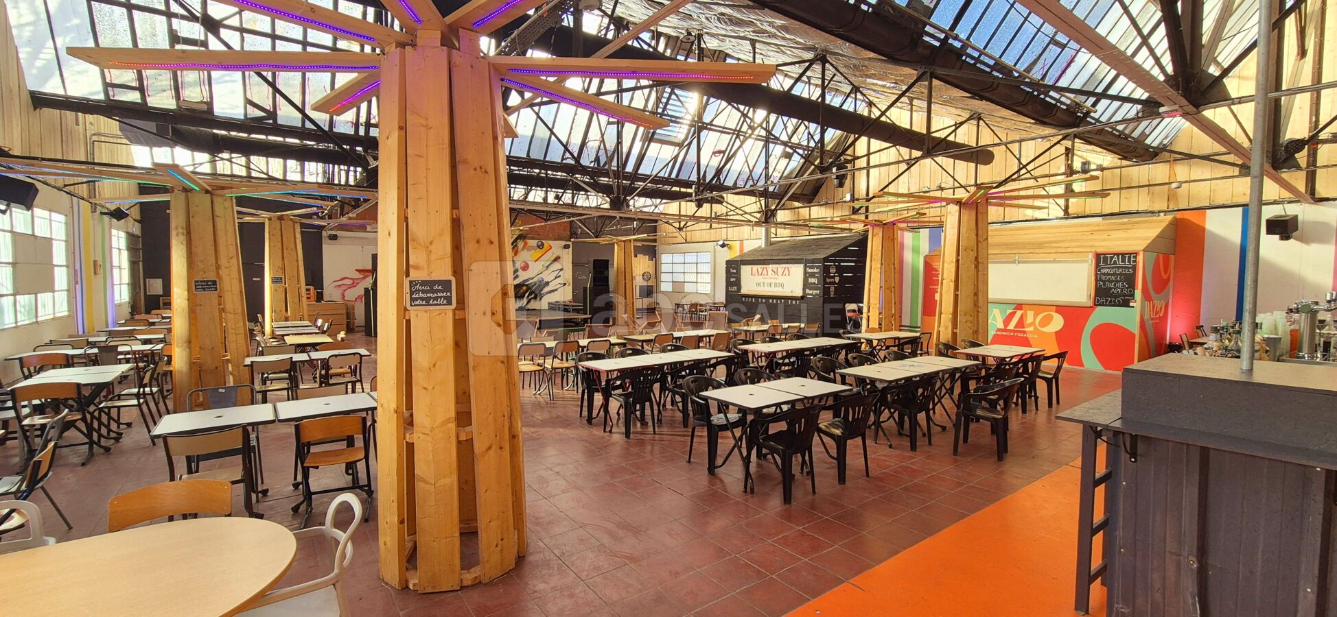 La salle en journée avec tables et transats