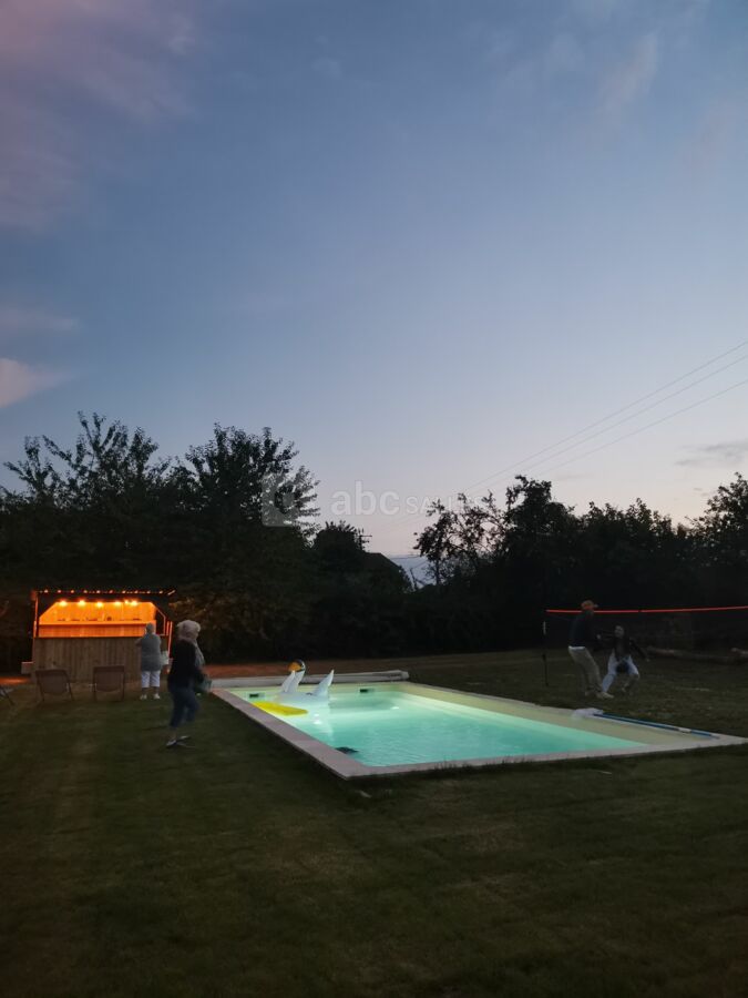 Piscine de nuit et son bar