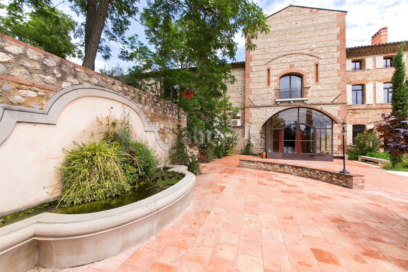 La terrasse et la fontaine du Jardin méditerranéen et vue sur l'entrée du Hall