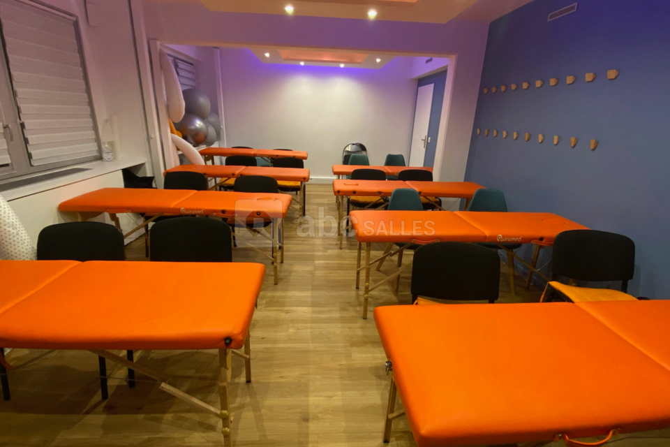 Salle de formation avec 8 tables de pratique ostéopathique et 32 chaises