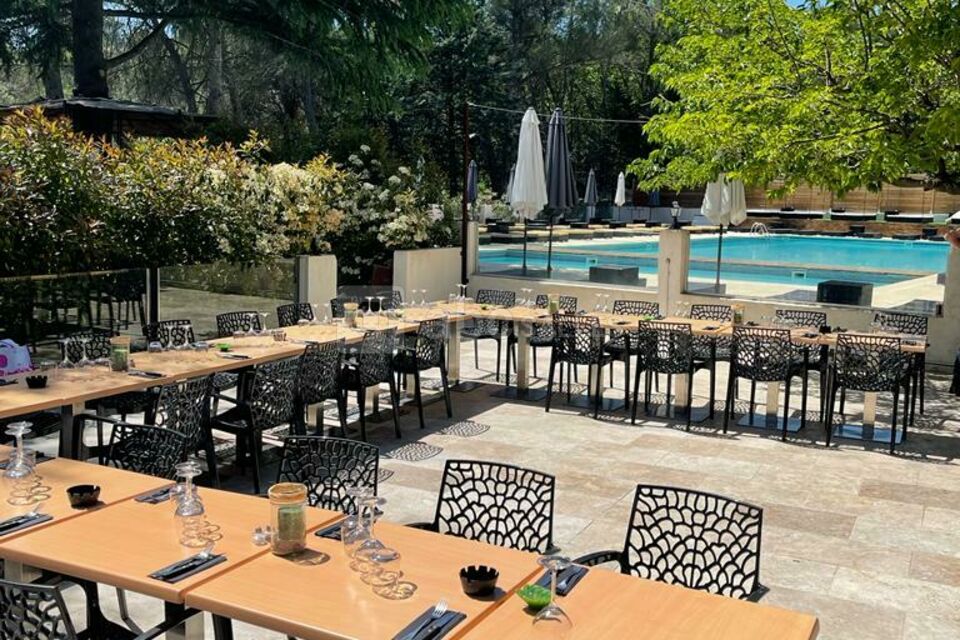 Une belle et grande terrasse d'été avec sa cuisine d'été et sa vue piscine