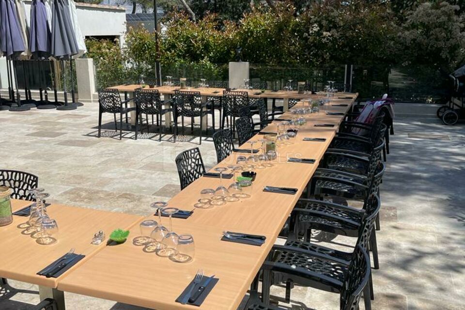 Une belle et grande terrasse d'été avec sa cuisine d'été et sa vue piscine