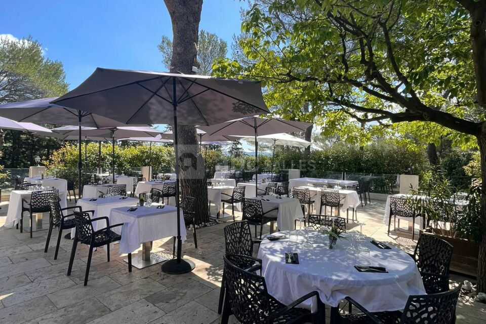 Une belle et grande terrasse d'été avec sa cuisine d'été et sa vue piscine